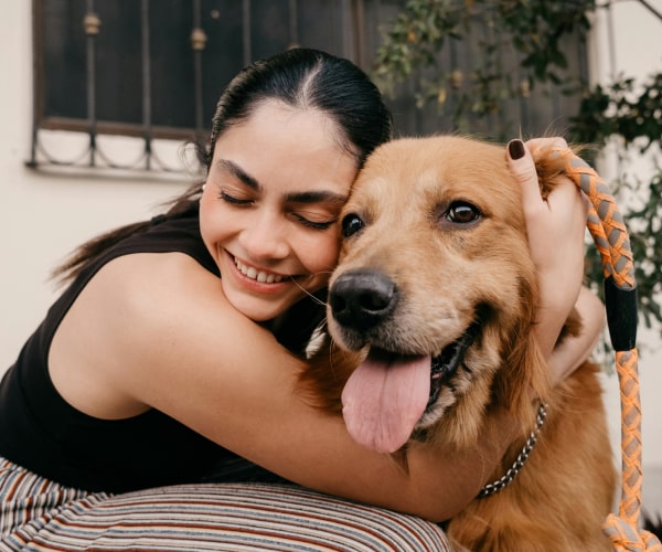 Girl hugging her happy pet dog